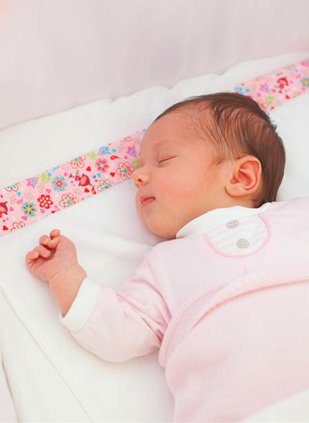 Portrait of sleeping newborn baby girl in the cradle.